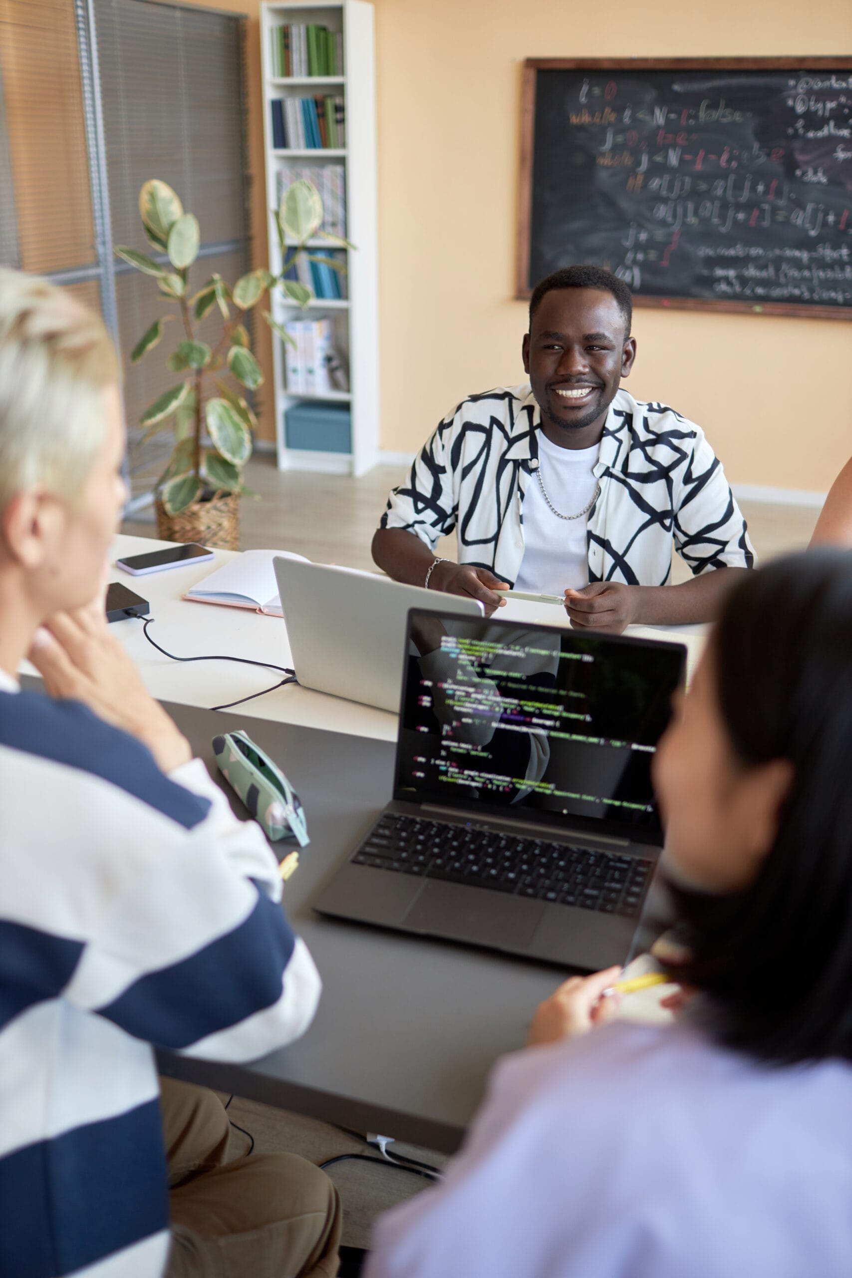 Young cheerful African American man having discussion with classmates | Bpointer Website Development Cost in India