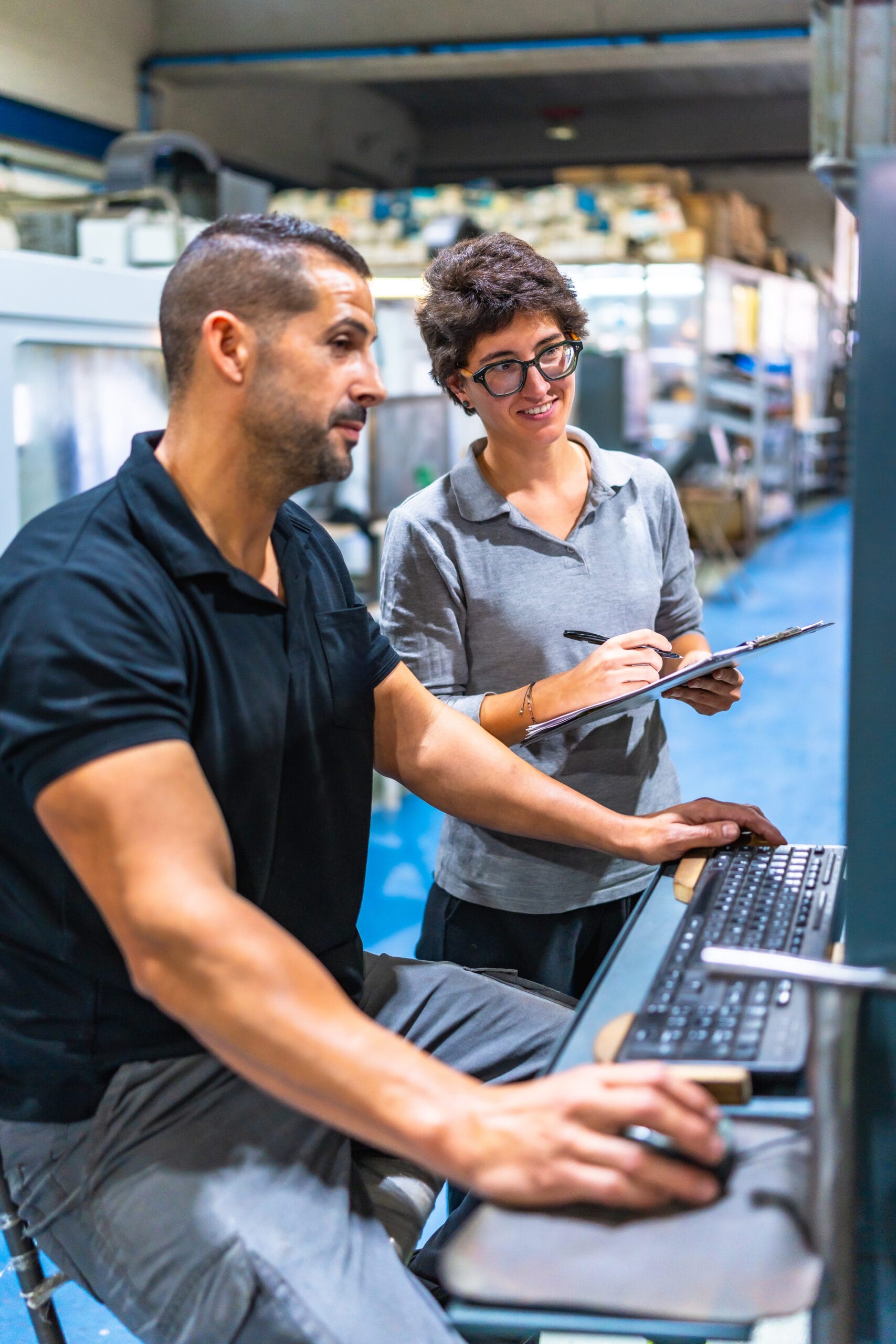 Engineer showing computer screen data to female manager at factory | Bpointer